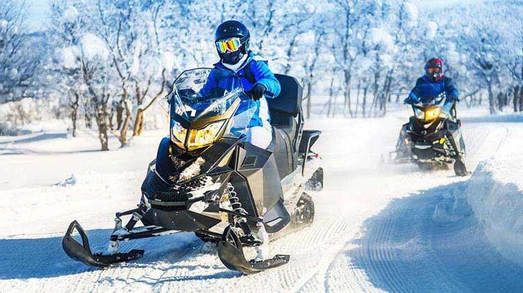 Two snowmobiles on a trail.